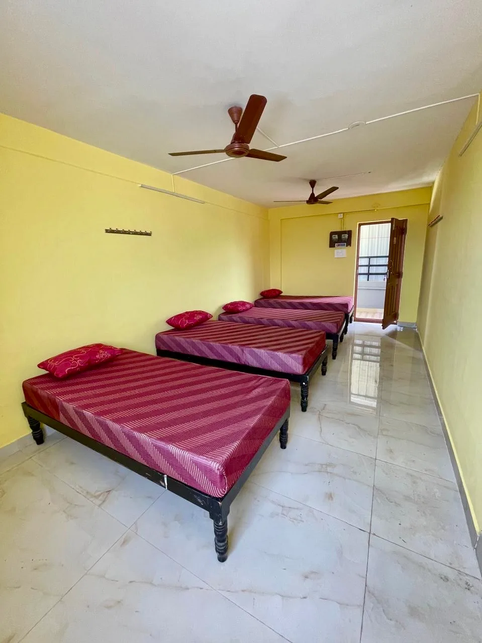 Spacious room at Q Residency – well-lit with ceiling fans